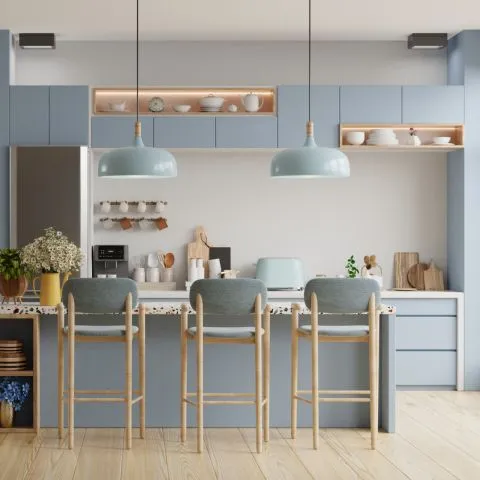 Cucina moderna e luminosa con mobili color blu pastello e sedie eleganti. preventivo ristrutturazione appartamento